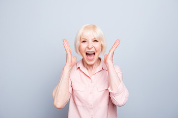 Old adult blonde glad excited cheerful astonished lady smiling, laughing, screaming, raising hands...