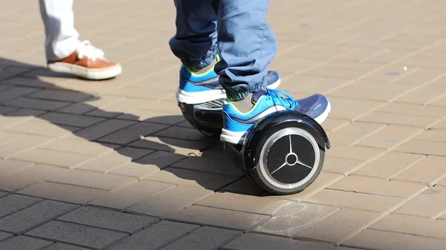 Boy legs riding segway on a pedestrian public street place slow motion