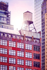 Water tank on a roof at sunset, color toned picture, New York City, USA.