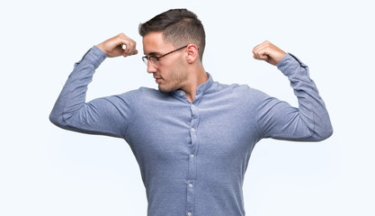 Fototapeta premium Handsome young elegant man wearing glasses showing arms muscles smiling proud. Fitness concept.