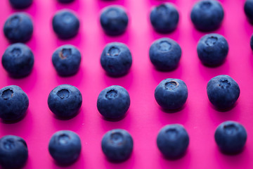 Close-up of a blueberry group on a pink background