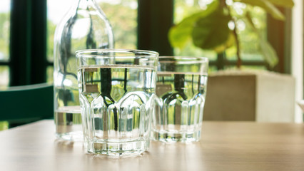 A glass of drinking water on a wooden table.