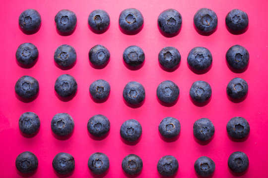 Top view of fresh ripe blueberries on pink background