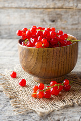 Fresh red currant berries on wooden background