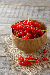 Fresh red currant berries on wooden background
