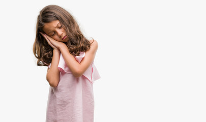 Brunette hispanic girl wearing pink dress sleeping tired dreaming and posing with hands together while smiling with closed eyes.