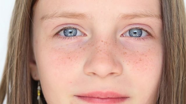 Beautiful blond young girl with freckles indoors , close up portrait