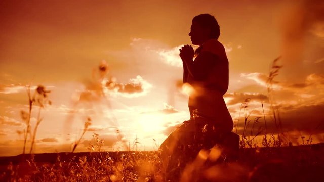 the girl lifestyle prays. Girl folded her hands in prayer silhouette at sunset. slow motion video. Girl folded her hands in prayer pray to God. girl praying asks forgiveness for sins of repentance