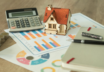 Financial paper and work station and house model with tablet on working table, business concept.