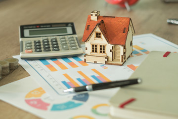 Financial paper and work station and house model with tablet on working table, business concept.