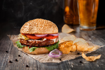 Burger BBK with chips on a dark wooden table