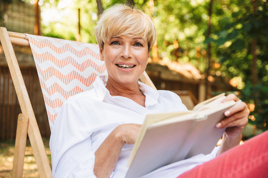 Excited mature woman reading a book