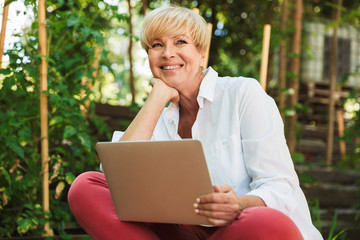 Cheerful mature woman using laptop computer