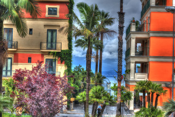 Fototapeta na wymiar Colorful buildings and palm tree in world famous Sorrento