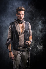 Good Looking Young Man Dressed in Pirate Fashion Outfit on Black Background with Smoke. Captured in Studio.