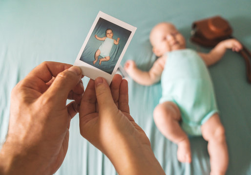 The first photo of a newborn in the hands of a man and a woman against a child. Instant photo in Polaroid style on heavy paper.