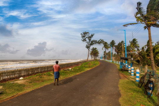 Rural fisherman walking along the scenic highway road near the sea beach at Digha Talsari, West Bengal, India.