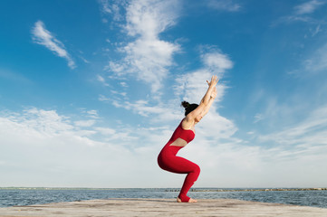 Young woman practicing yoga on the beach