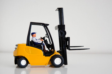 Fototapeta na wymiar Children's toy forklift with driver, educational toy