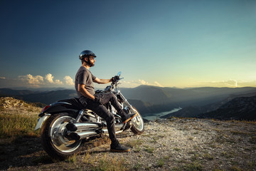 Obraz na płótnie Canvas Biker leaning on a motorcycle