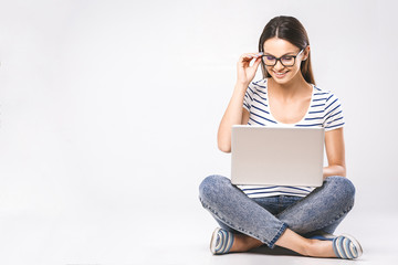 Business concept. Portrait of happy woman in casual sitting on floor in lotus pose and holding laptop isolated over white background. - obrazy, fototapety, plakaty