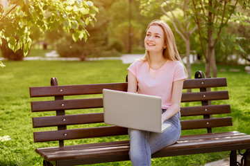 girl with a laptop sitting on a bench