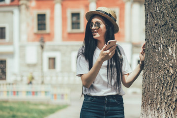Fototapeta premium Pretty brunette woman internet blogger talking by smartphone in old city