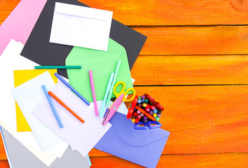 School supplies. Back to School design elements. Colorful markers and white empty paper sheet on aged wooden table.