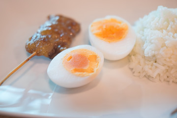 Grilled pork and boiled egg served with cooked Jasmine rice
