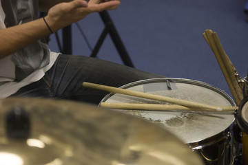 Drummer placing drum sticks on snare drum.