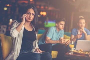 Young woman using mobile phone in front of her team in startup office