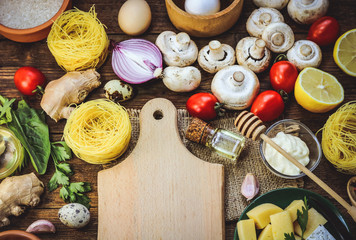 food ingredients - mushrooms, cheese, spaghetti - nests. wooden plank. place for text.