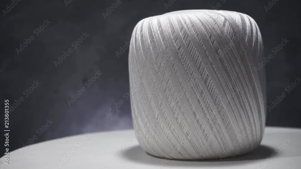 Poster white thread of tangle on a table, rotation 360 degrees.