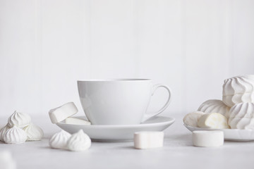 Fototapeta na wymiar Cup of coffee on white background. Marshmallows, sweets and coffee beans.