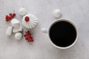 Cup of coffee, white background. Marshmallows, red berries.