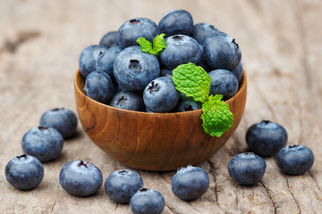 Blueberries in a wood bowl on a wooden table, Healthy eating and nutrition concept