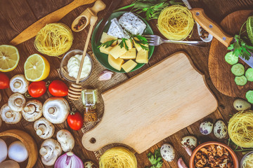 food ingredients - mushrooms, cheese, spaghetti - nests. wooden plank. place for text.