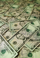 Heap of United States five dollar bills with selective focus and blurred background  