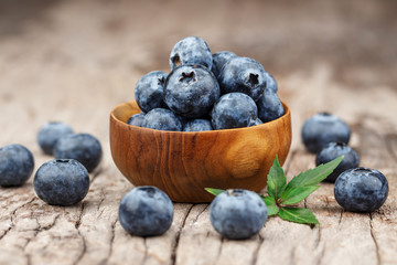 Blueberries in a wood bowl on a wooden table, Healthy eating and nutrition concept