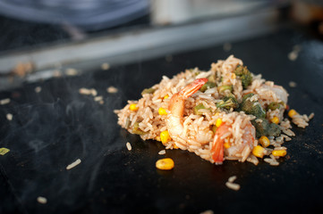 The process of cooking rice with vegetables. Asian cuisine. Street food.