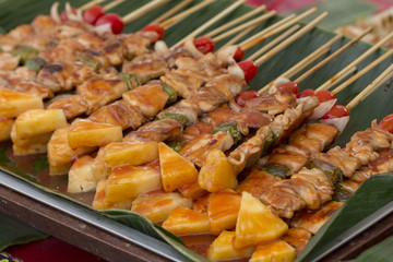 Pork barbecue sticks with tomato, pineapple and bell pepper on banana leaf ,Thailand.