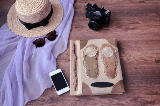 photo album with camera, phone, parero, straw hat and sunglasses