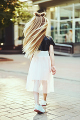 Lifestyle portrait of stylish little girl teenager. Beautiful child, wearing black jacket, pink skirt. Beautiful long hair.