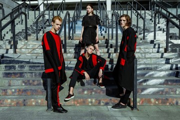 Obraz premium four young people in stylish clothes posing outdoors 