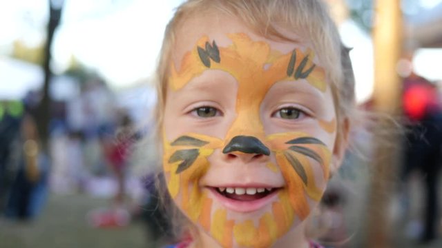Body art painting on smile face of little cute child girl - happy childhood portrait