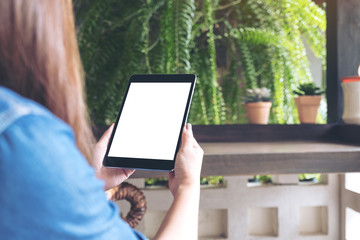 Mockup image of woman holding black tablet pc with white blank desktop screen with green nature background