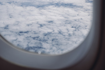 The blue sky on cloudy day through an airplane window