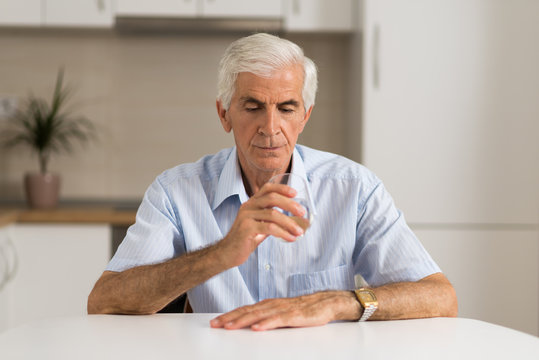 Old Man About To Drink Glass Of Water At Home