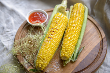 Grilled corn with salt and butter on the kitchen board © olegkruglyak3