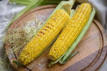 Corn grilled with salt on a kitchen board